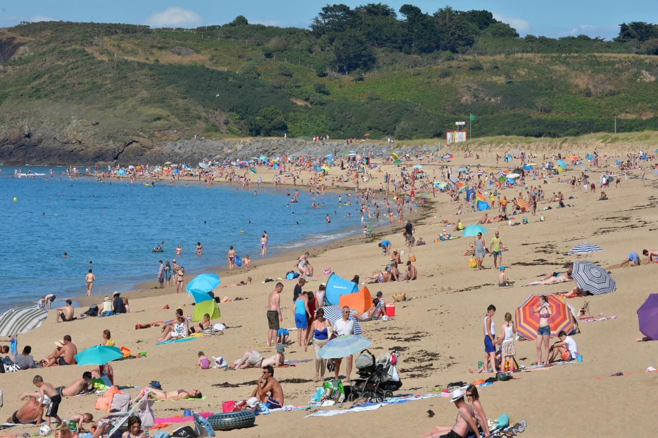 De nombreuses personnes sont sur le sable d'une plage